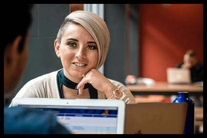 A female graduate student chatting with a male graduate student. 