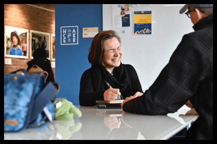 Female graduate student shares a laugh with another graduate student in a WVU common area. 